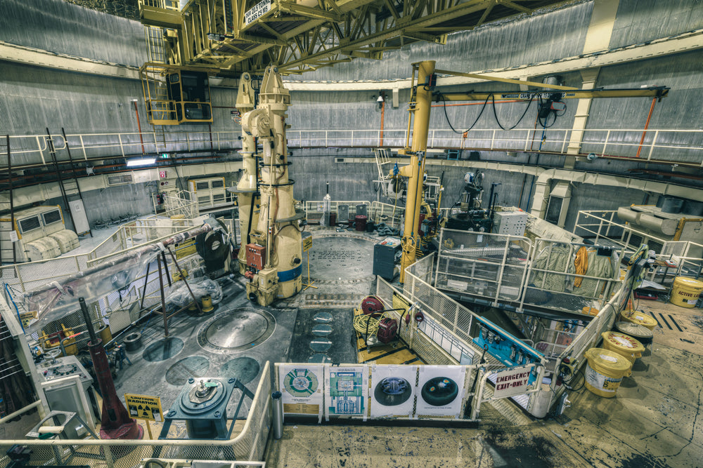 Top Plate Beneath Polar Crane at ANSTO HIFAR, yellow lab coats hang on the mesh walls of the right walkway, worn.