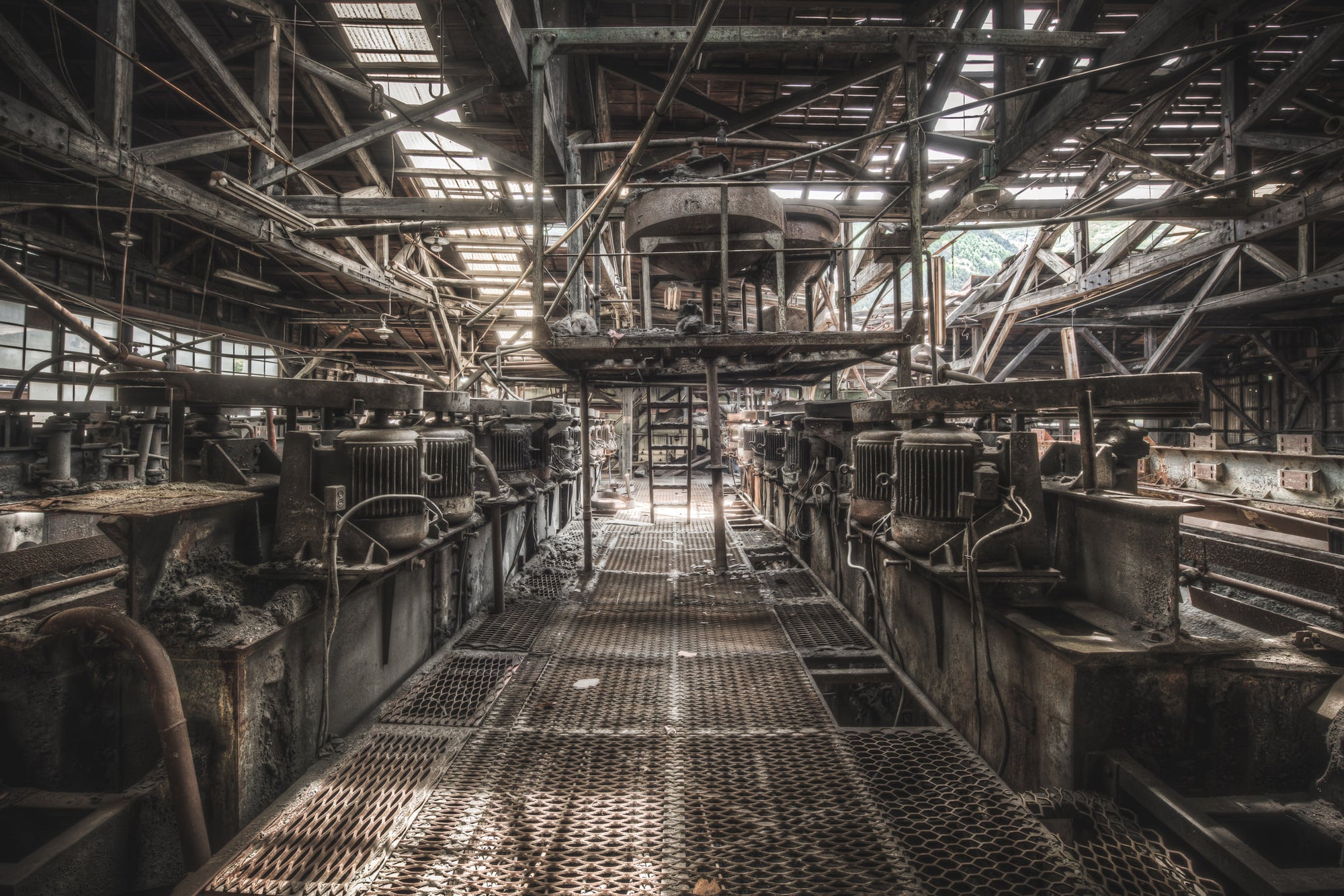 Cleaning Flotation at Ashio Copper Mine, flotation cells line both sides of a narrow steel grating walkway.