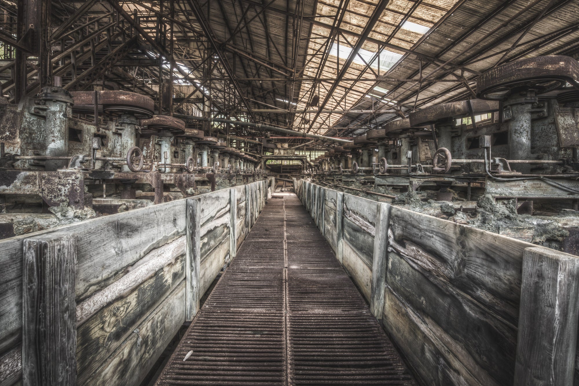 Froth Flotation Cells at Ashio Copper Mine, a narrow metal grating walkway runs between two rows of timber-lined flotation.