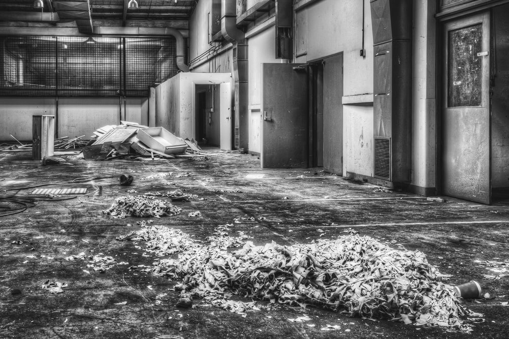 Canteen at ATL Building, a heap of crumpled fabric or paper sits in the centre of a bare concrete floor.