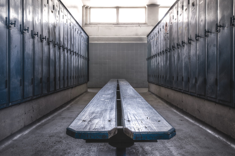 Rows of dark blue-grey metal lockers and a worn timber bench in the change room at Awaba Colliery, photographed in 2015.