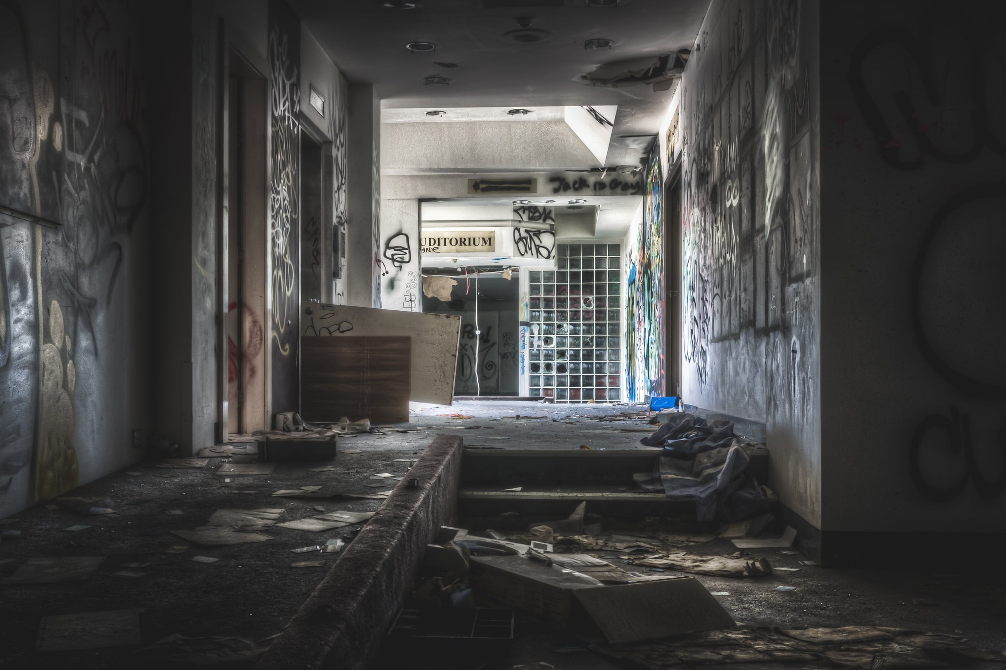 Auditorium Entrance at Balmain Leagues Club, a corridor leads toward a glass-block wall at the far end, where a sign.