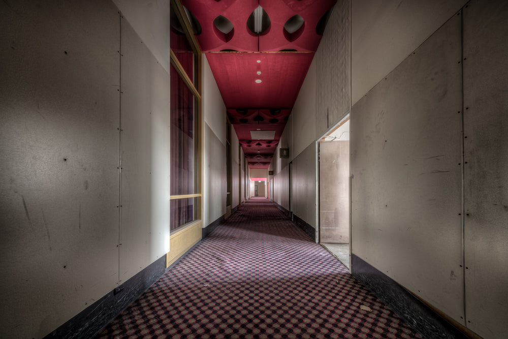 Auditorium Corridor at Bankstown RSL, a long corridor stretches deep into the building, narrowing to a vanishing point lit.
