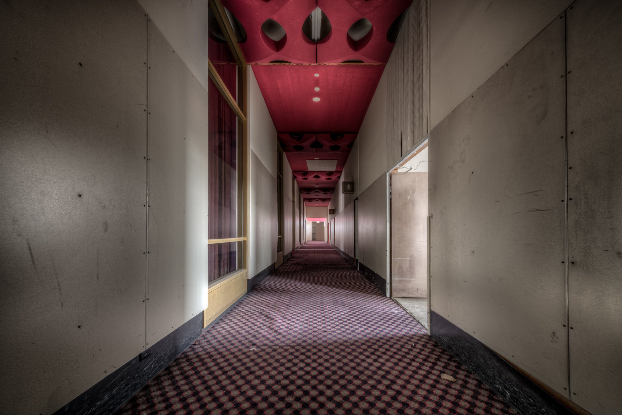 Auditorium Corridor at Bankstown RSL, a long corridor stretches deep into the building, narrowing to a vanishing point lit.