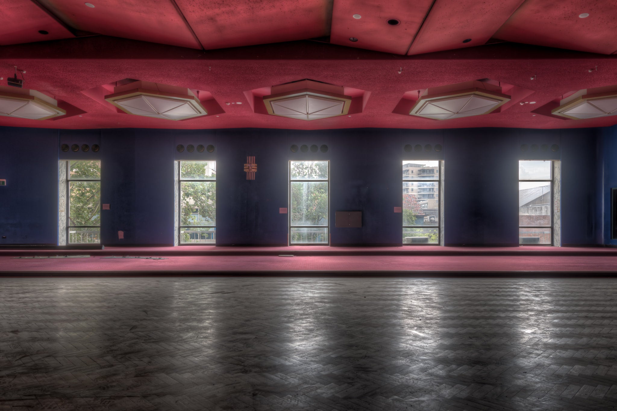 Auditorium Windows at Bankstown RSL, a wide auditorium floor stretches toward a bank of tall windows.
