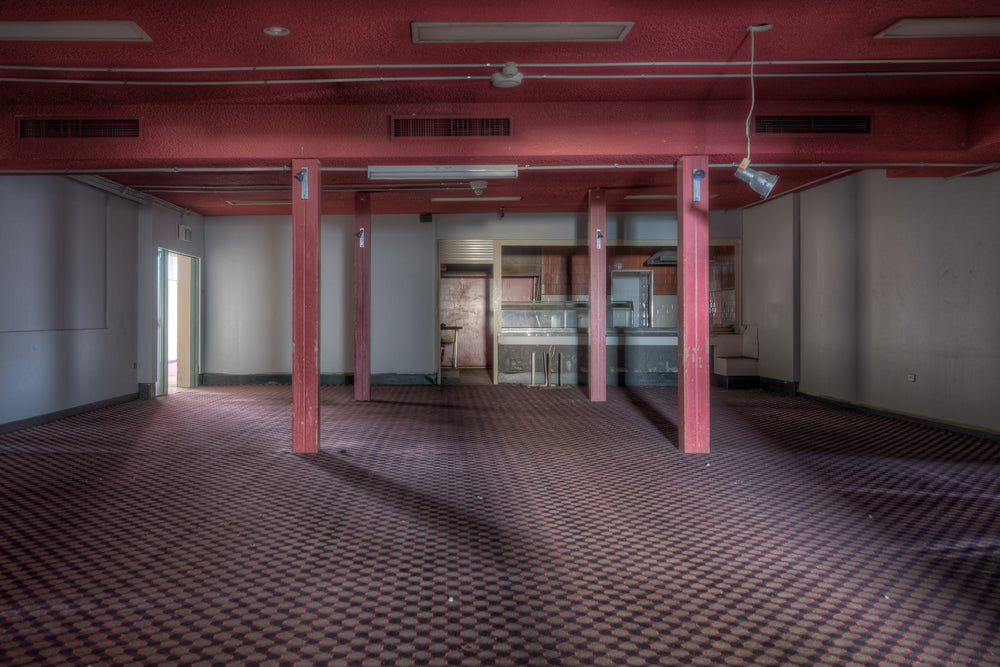 Bistro at Bankstown RSL, red steel columns divide the room at regular intervals, holding a low ceiling painted the same.