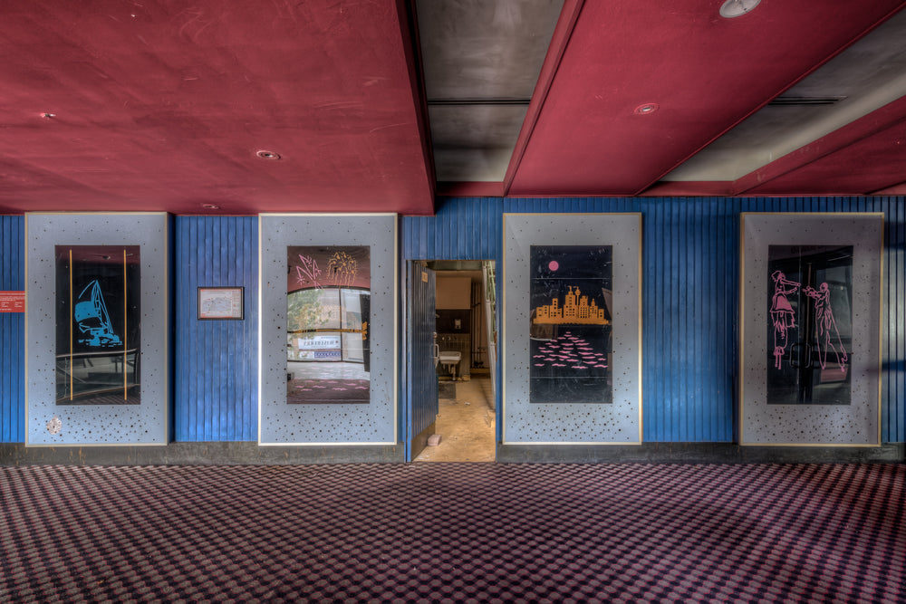 Foyer Art at Bankstown RSL, five framed artworks line the foyer wall, mounted on blue timber panelling punctuated.
