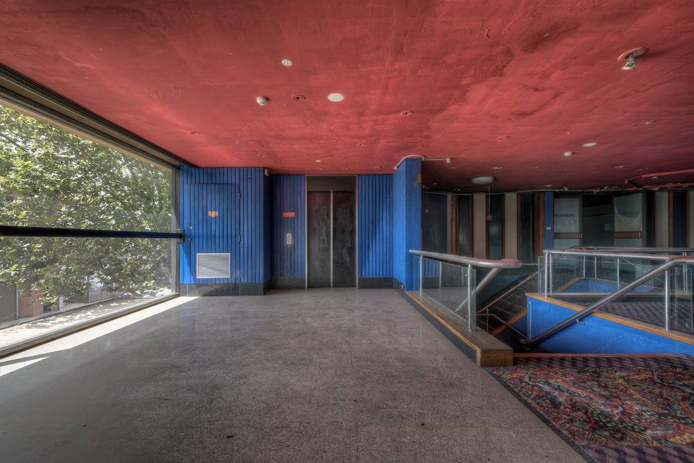 Foyer Stairs Elevator at Bankstown RSL, a deep red ceiling hangs low over polished concrete.