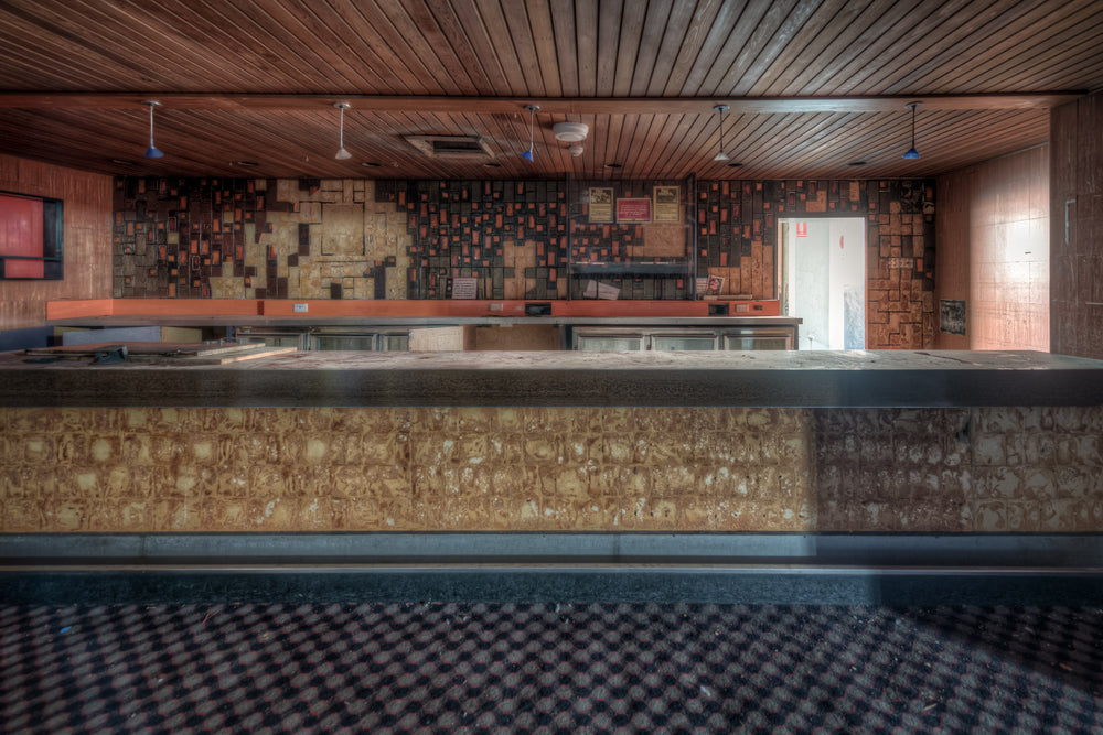 Nightclub Bar at Bankstown RSL, a long bar counter runs the width of the room, its stone-clad face pitted and uneven.