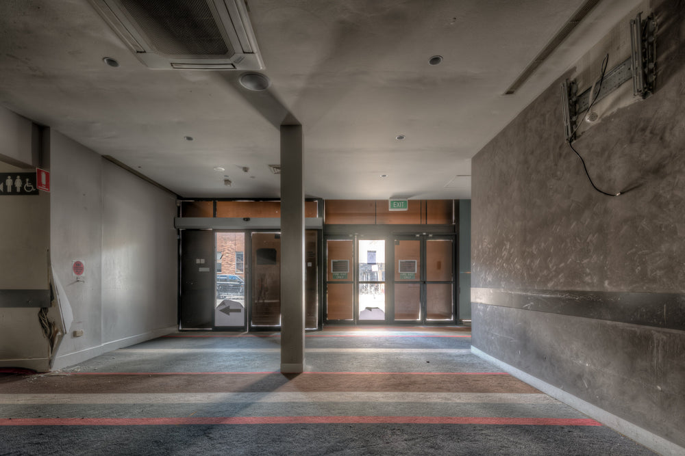 RSL Entrance at Bankstown RSL, a concrete column stands centre-frame, splitting the foyer into two grey corridors.