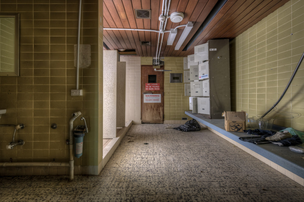 Showers at Bankstown RSL, olive-green ceramic tiles line the walls of a disused sauna and shower area.