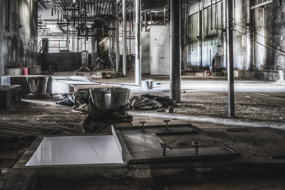 Hide Puller at Blayney Abattoir, a stainless steel bowl sits on crumpled tarpaulin beside an open floor chute.
