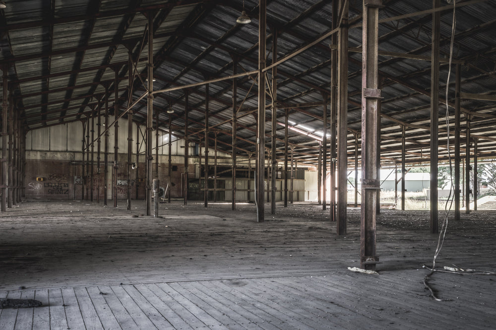 Skin Shed at Blayney Abattoir, steel columns run in rows across a wide timber floor, supporting a corrugated iron roof held.