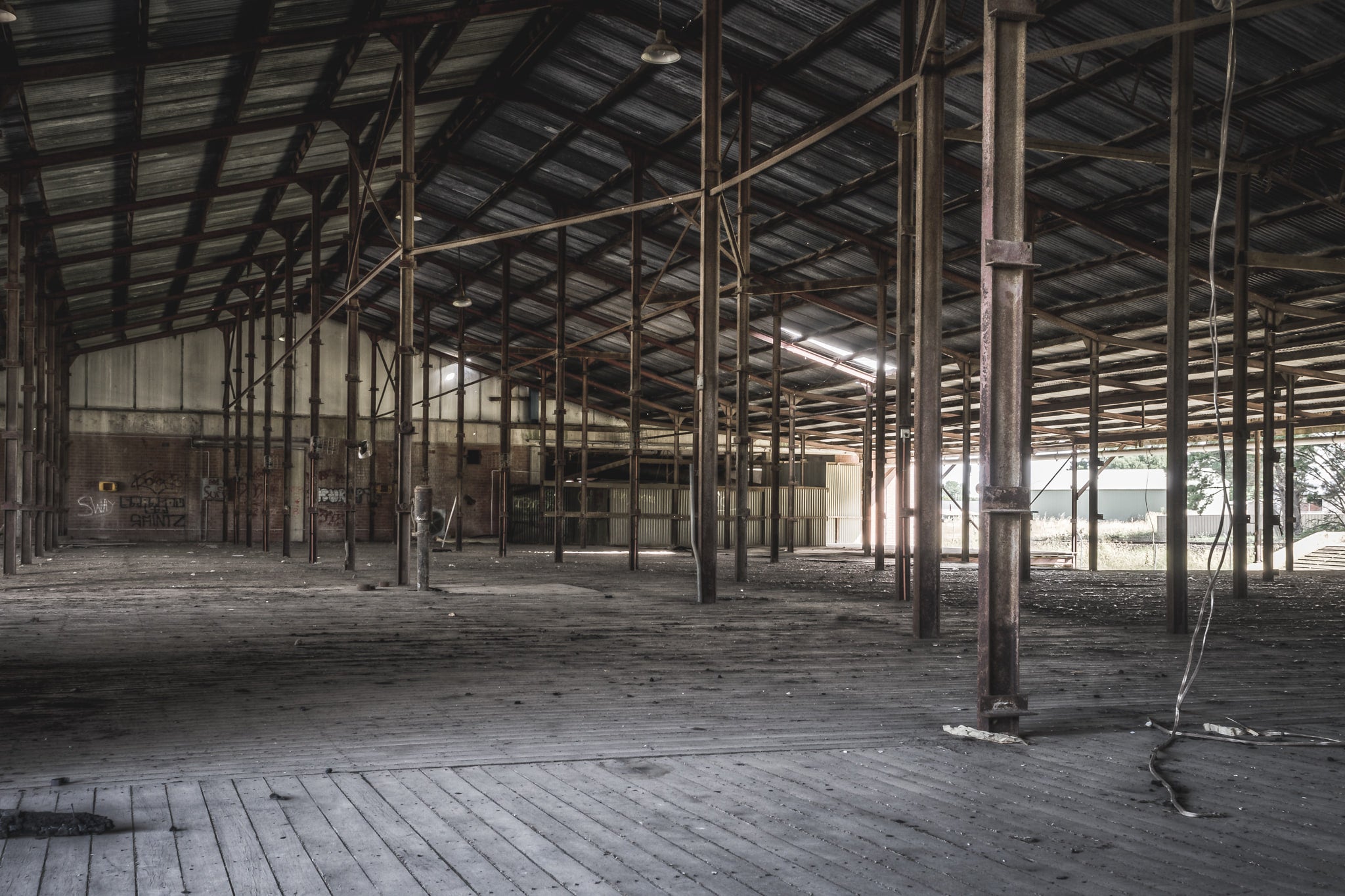 Skin Shed at Blayney Abattoir, steel columns run in rows across a wide timber floor, supporting a corrugated iron roof held.