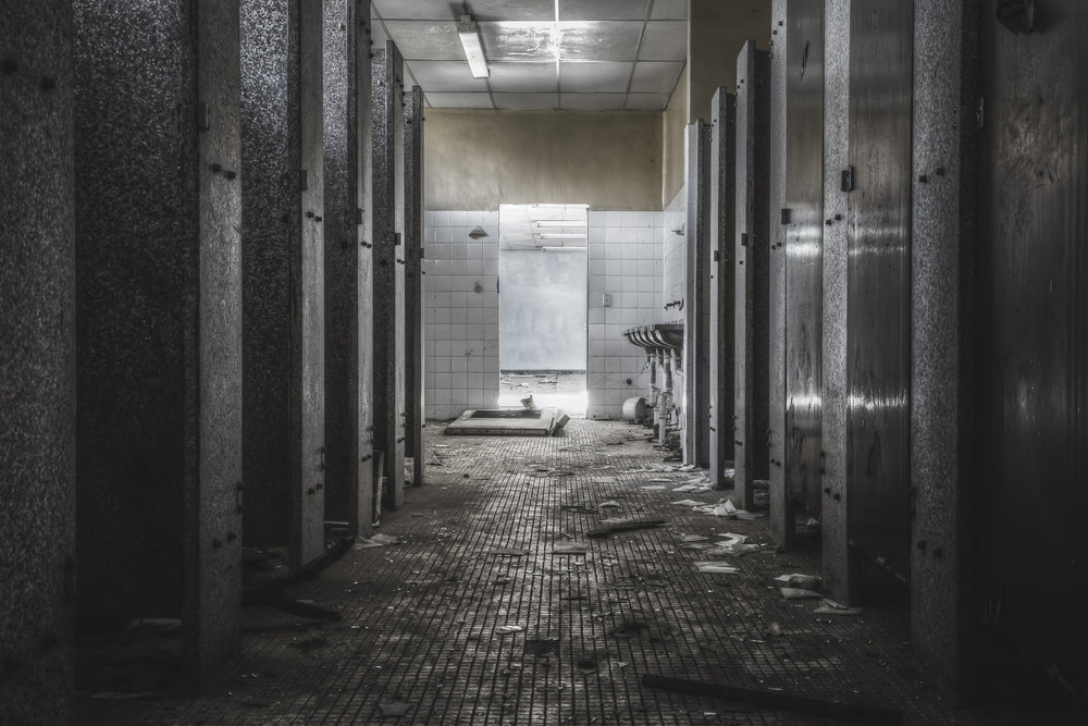 Toilet Block at Blayney Abattoir, stalls line both sides of this abandoned toilet block, their doors still mostly in place.
