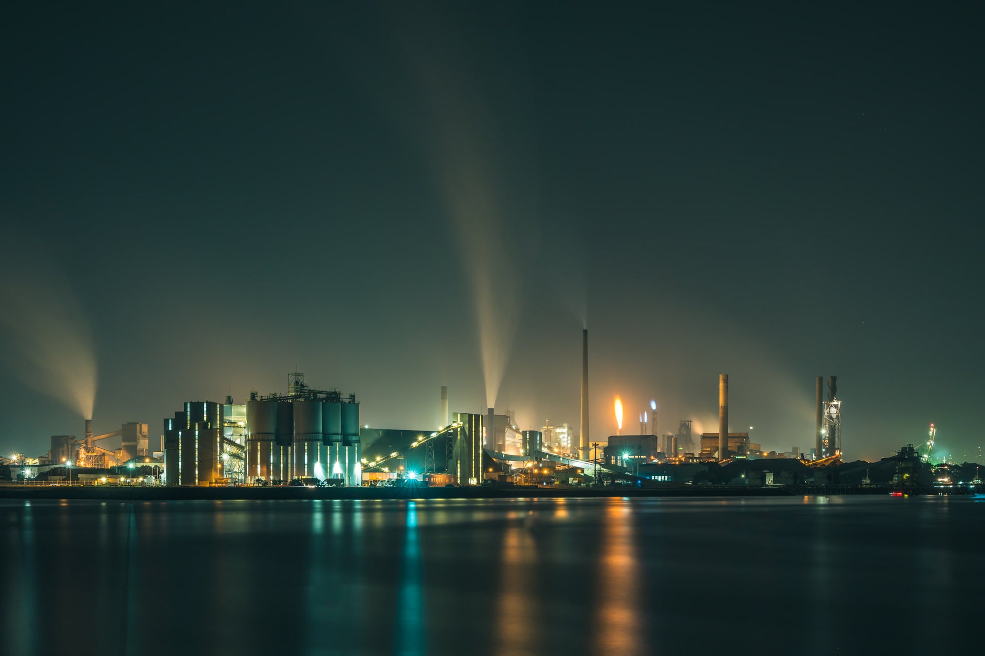 Port Kembla At Night at BlueScope Port Kembla, steam columns rise from the BlueScope steelworks and dissolve into low cloud.