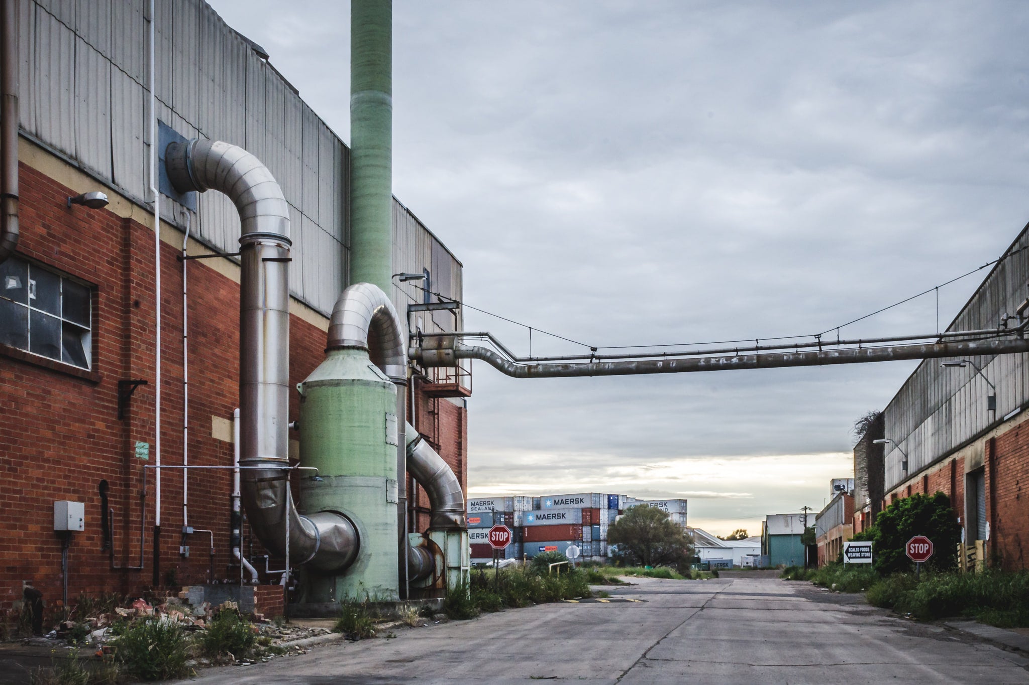 Chemical Plant at Bradmill Denim, a green dust extraction unit stands bolted to the red brick facade of a factory building.