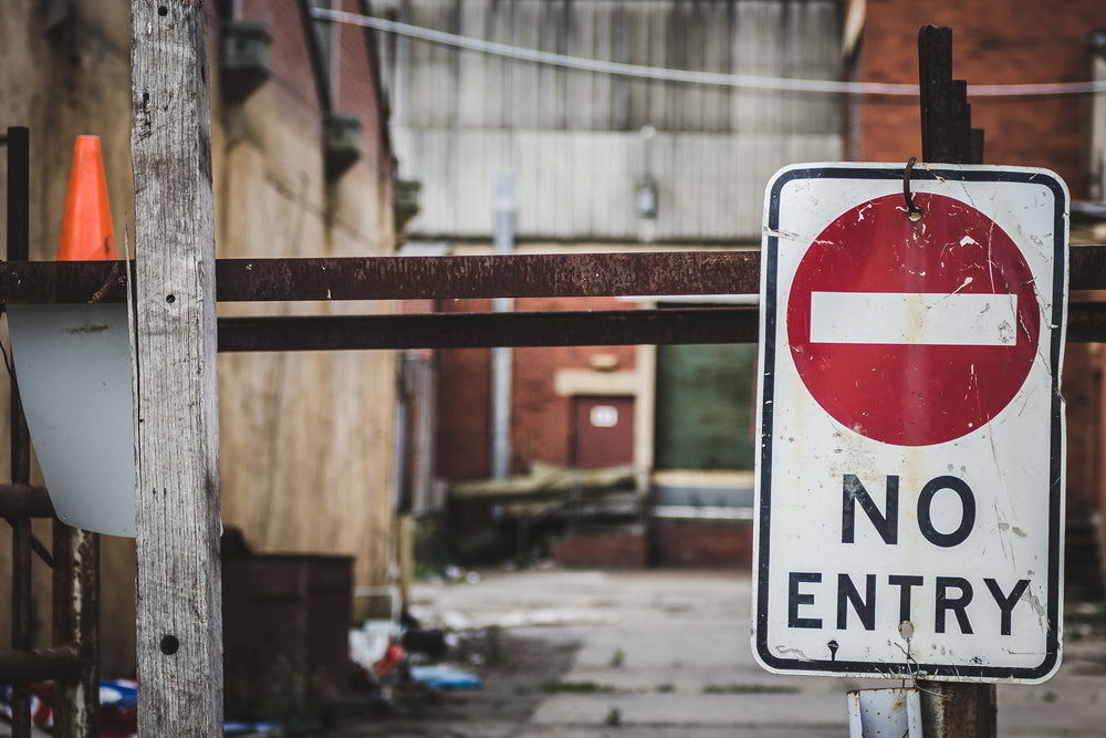 No Entry at Bradmill Denim, a scuffed No Entry sign hangs from a steel gate at the Bradmill compound.