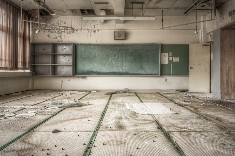A classroom at Family School Fureai in Yubari, Hokkaido, its green chalkboard still carrying chalk marks at the back of the room.