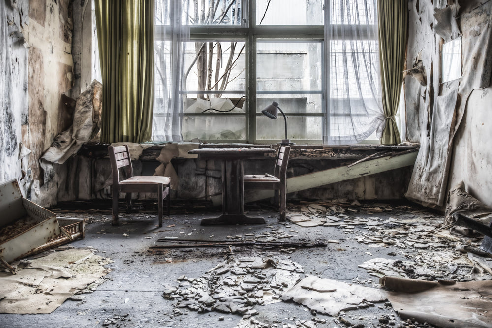 Decaying Tuition Room at Family School Fureai, two chairs sit at a pedestal table against a bay window.