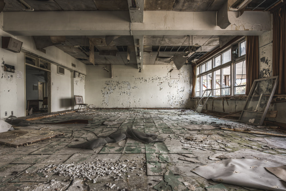 School Room at Family School Fureai, pieces of the ceiling have fallen to the floor, and the flooring has separated.