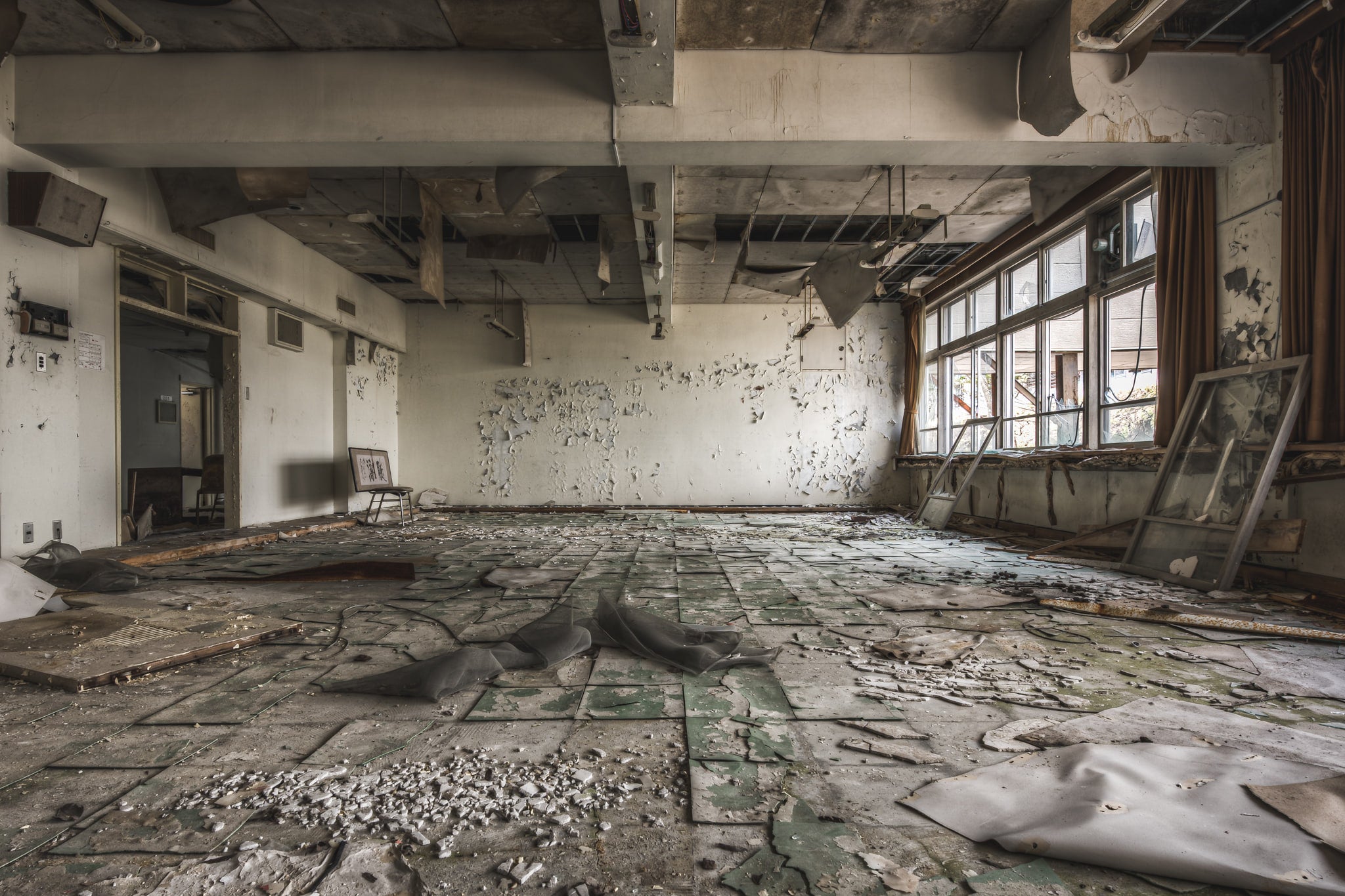 School Room at Family School Fureai, pieces of the ceiling have fallen to the floor, and the flooring has separated.