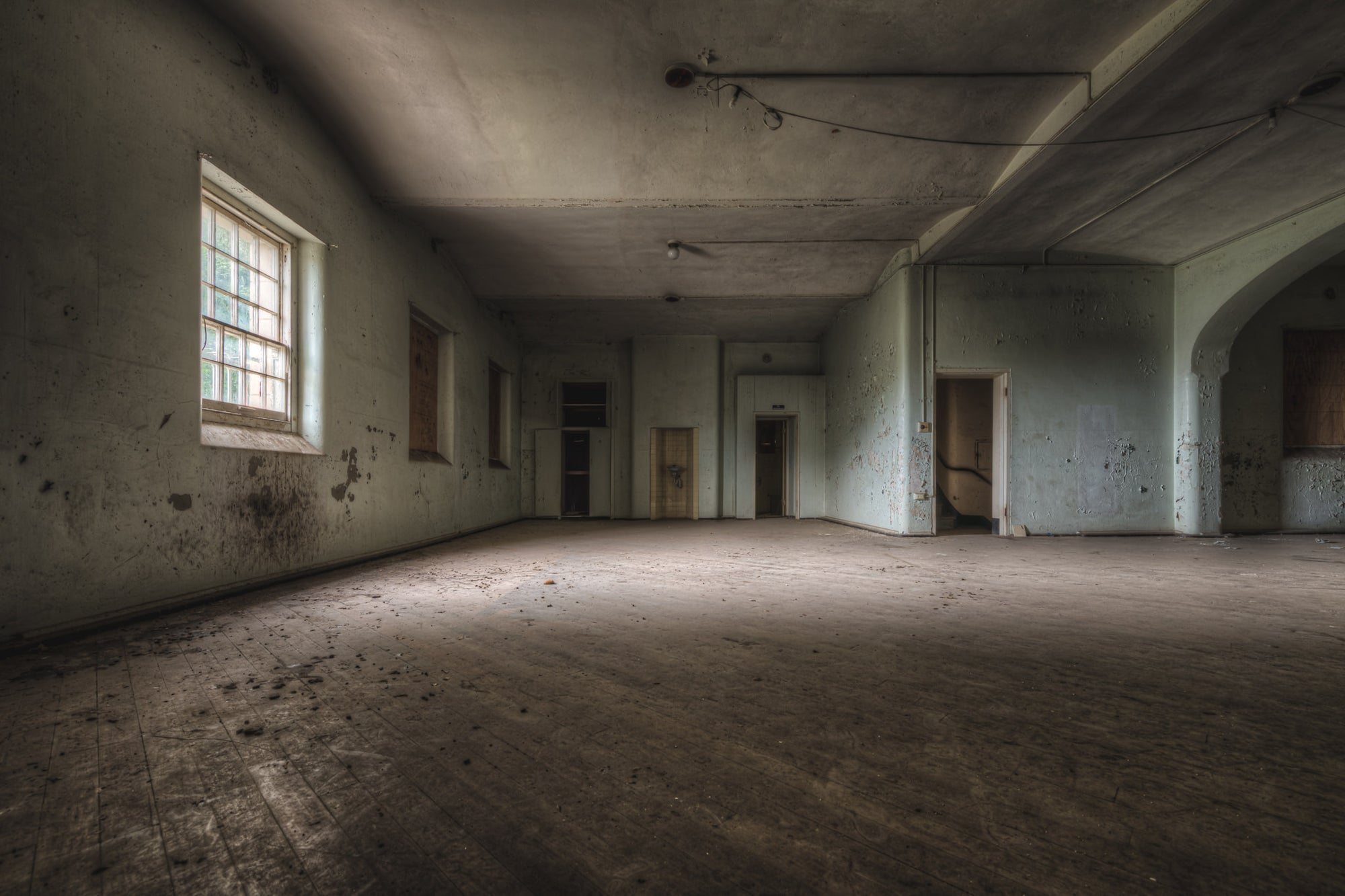 Soft Light at Female Ward 9 & 10, a single window throws pale light across a bare concrete floor.