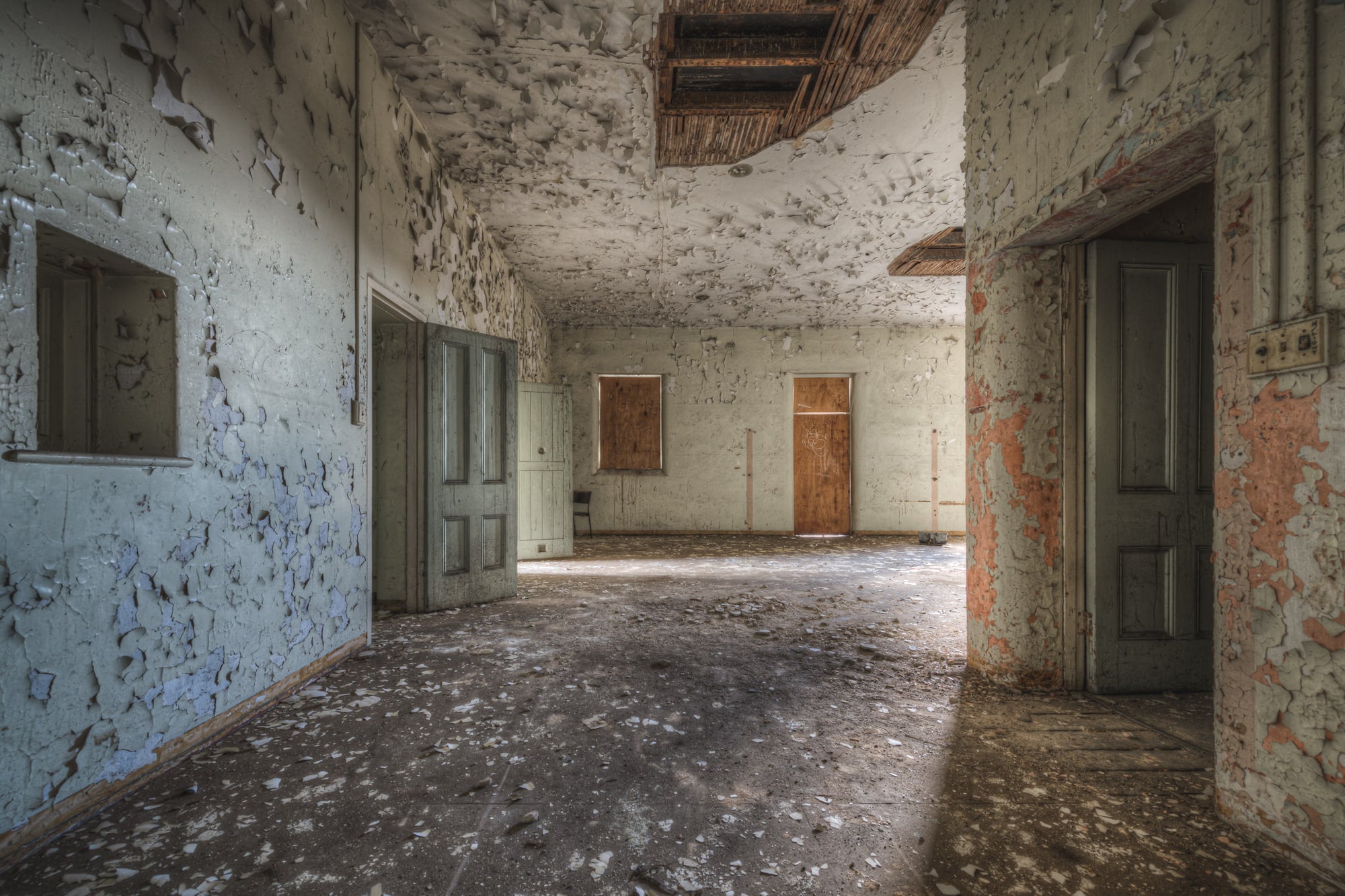 Upstairs Ward at Female Ward 9 & 10, paint peels from every surface in wide, brittle curls.