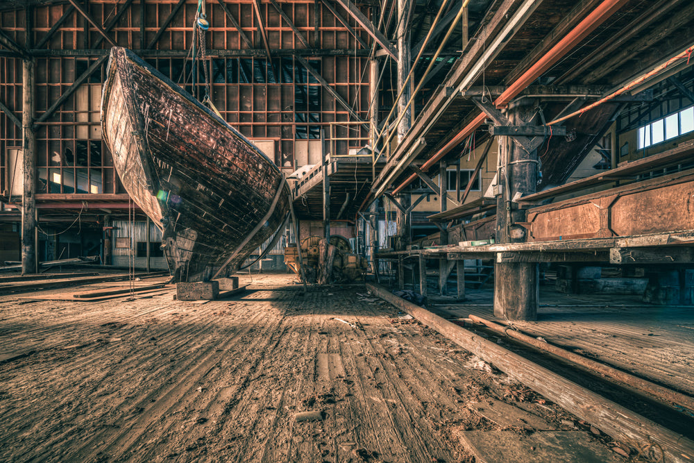 Hull at Halvorsens Boat Yard, a timber hull sits propped on blocks inside the main construction shed.