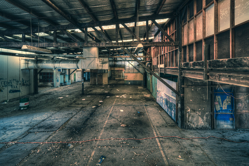 Mezzanine at Halvorsens Boat Yard, steel trusses span the full width of the shed, bolted to rust-streaked columns.
