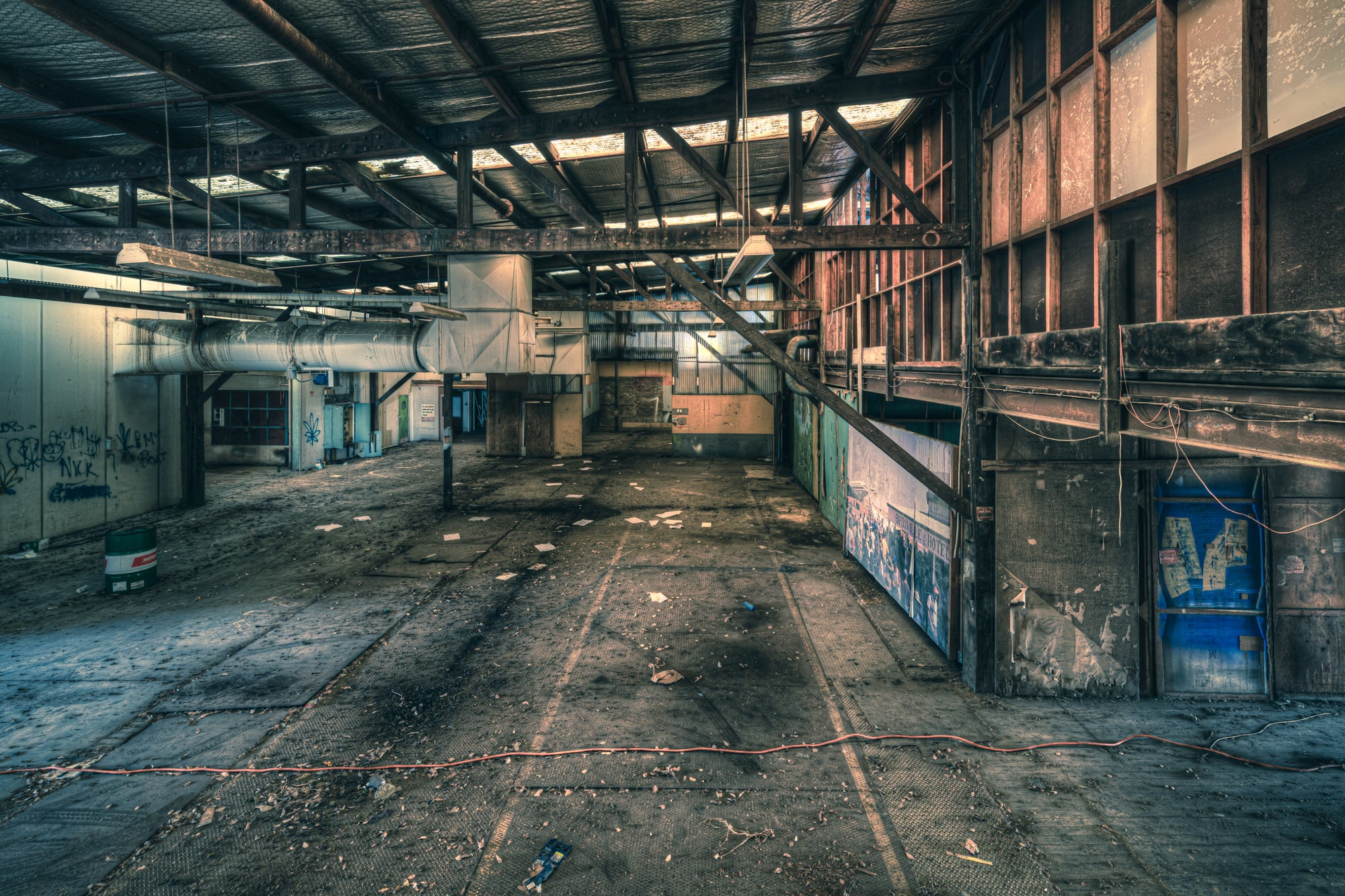 Mezzanine at Halvorsens Boat Yard, steel trusses span the full width of the shed, bolted to rust-streaked columns.