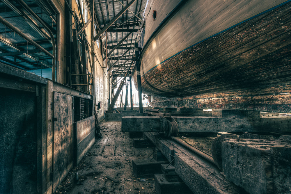 On Rail at Halvorsens Boat Yard, a timber hull sits cradled on steel rails inside the shed at Halvorsens Boat Yard.