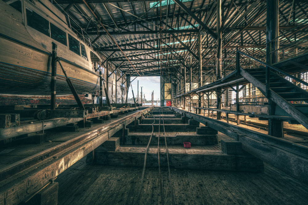 Sleeper Row at Halvorsens Boat Yard, heavy timber sleepers run in parallel lines down the centre of the shed, steel cables.
