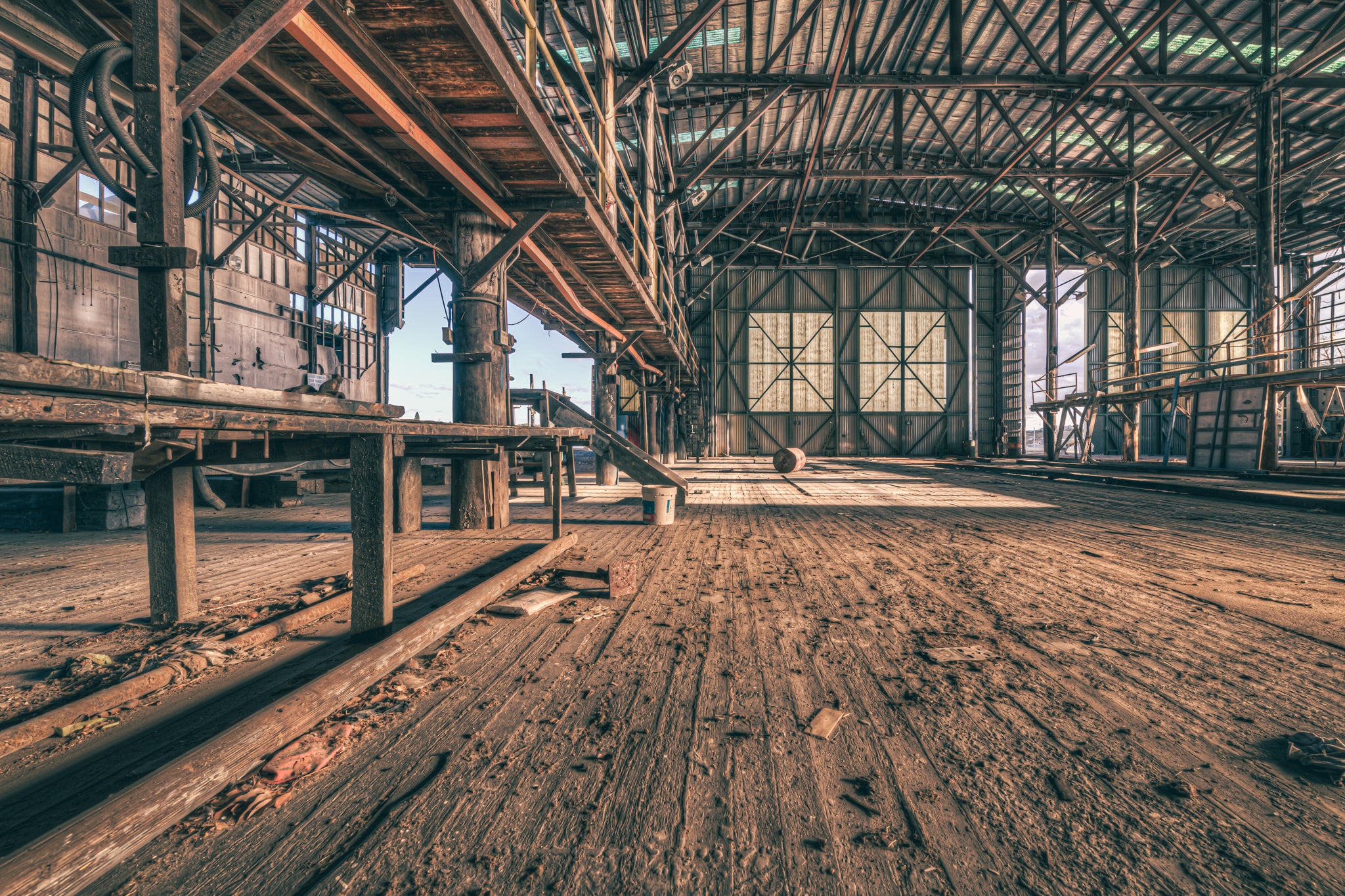 Workshop Floor at Halvorsens Boat Yard, worn timber planks stretch the full length of the workshop floor, their grain split.