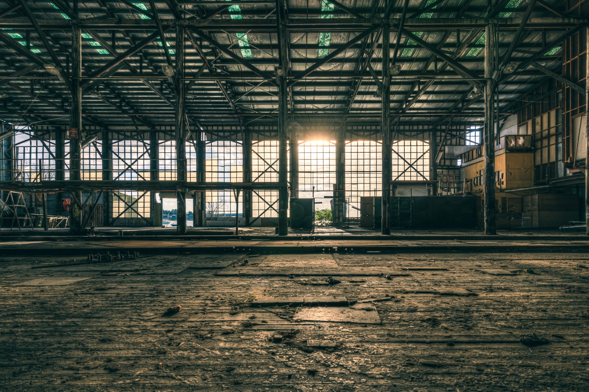 Workshop Sunset at Halvorsens Boat Yard, low sun pushes through the enormous gridded windows at the far end of the workshop.