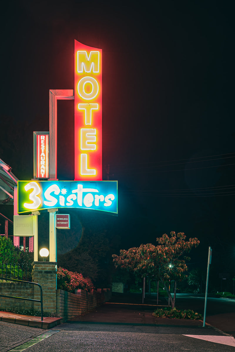 3 Sisters Motel Sign at Hotel Motel 101, red neon outlines the tall MOTEL blade.