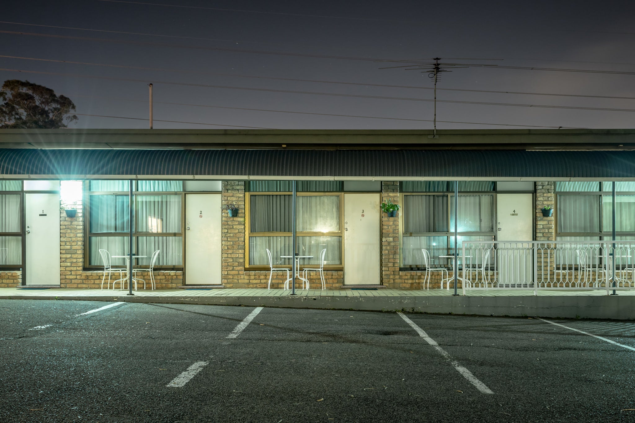 Abcott Inn at Hotel Motel 101, four rooms face an empty car park.