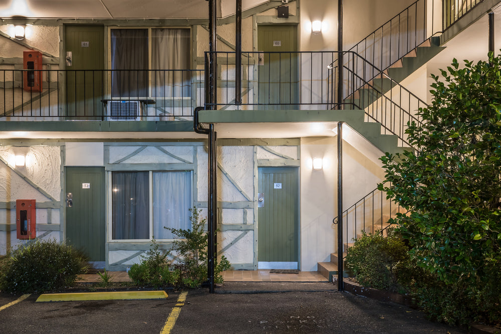 Ascot Motor Inn at Hotel Motel 101, two storeys of rendered blockwork and green-painted timber doors.