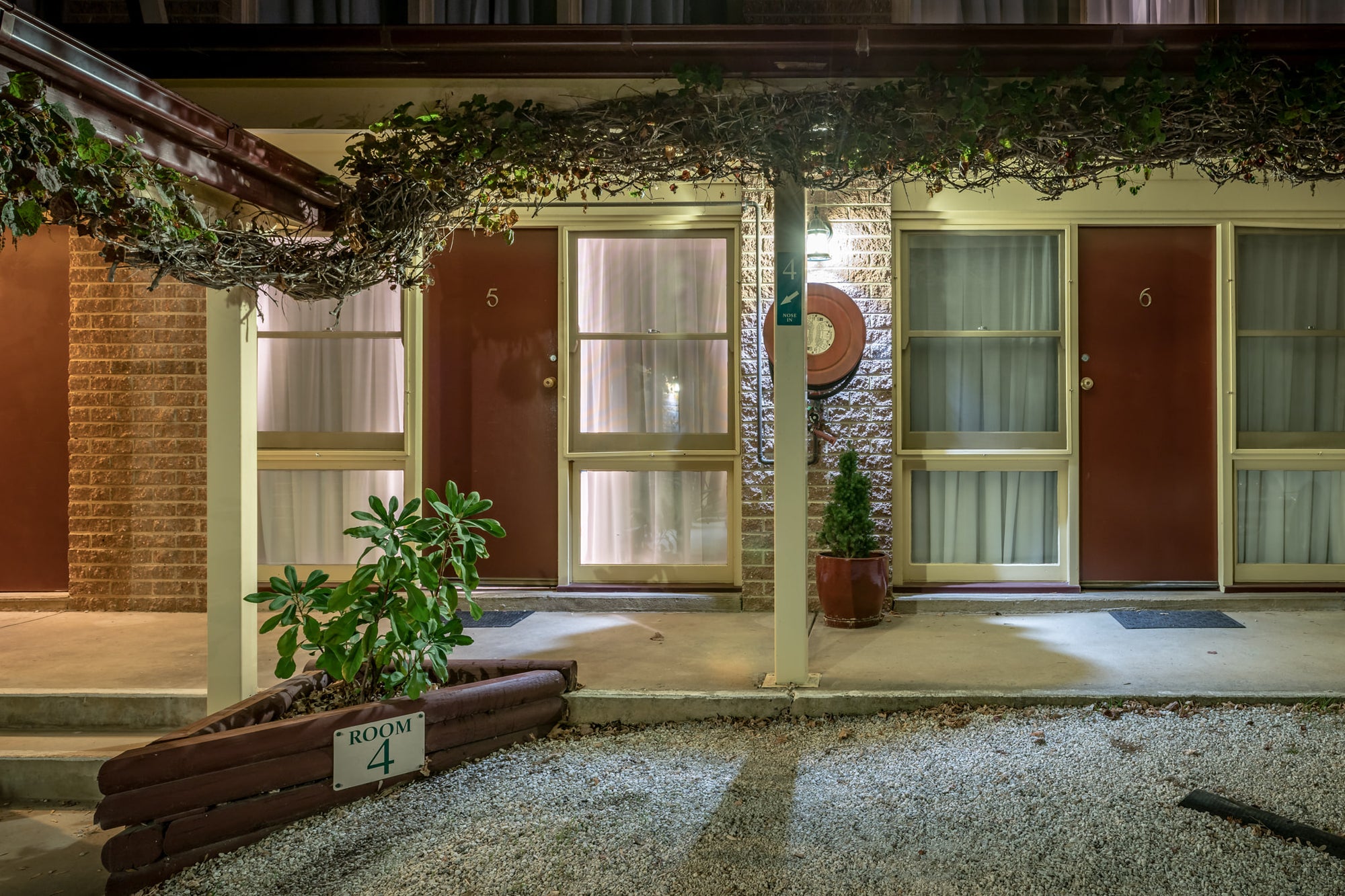 Berrima Bakehouse Motel at Hotel Motel 101, rooms 4, 5 and 6 face a gravel car park under flat fluorescent light.