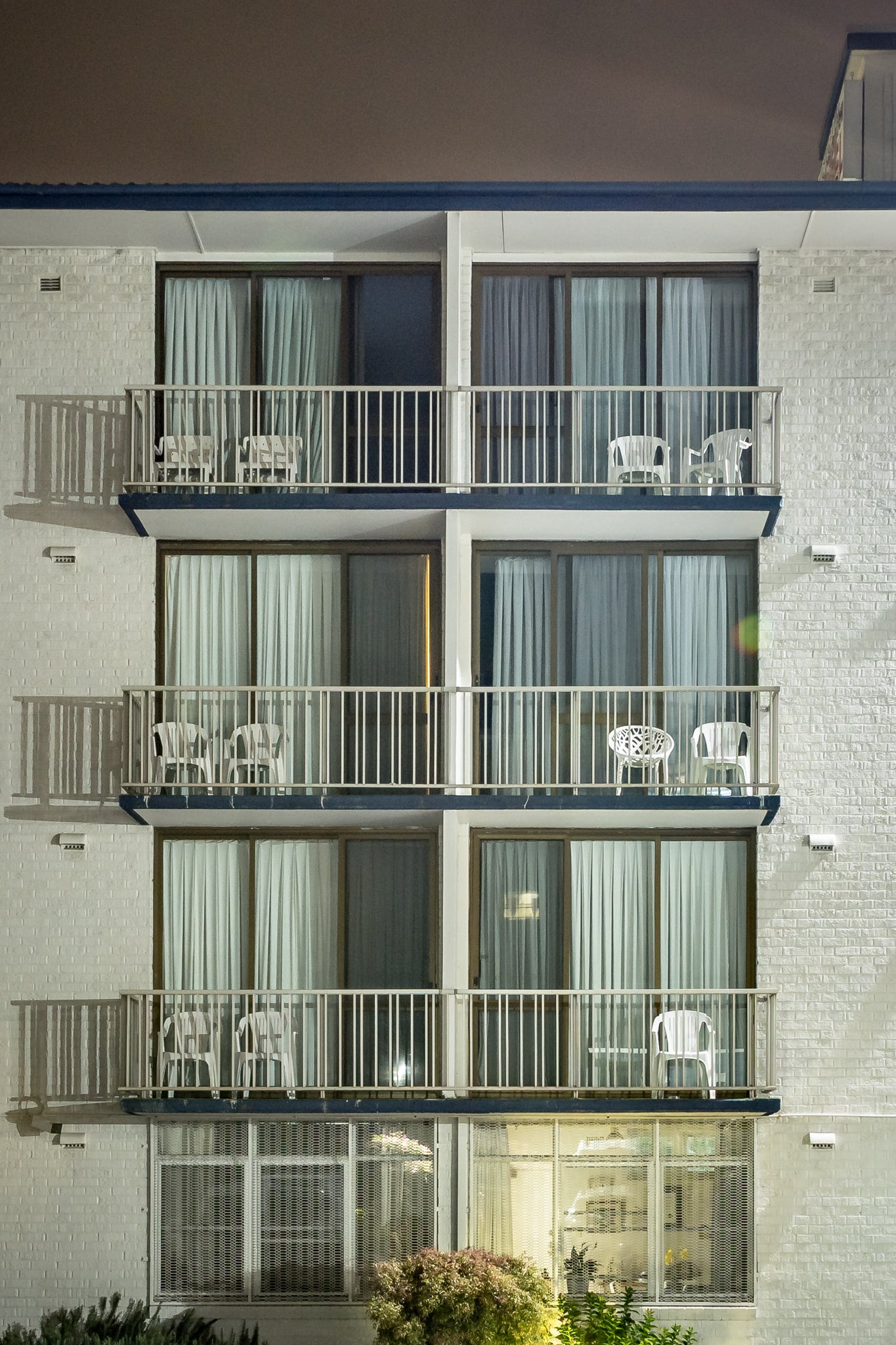 Boat Harbour Motel at Hotel Motel 101, three storeys of white-painted brick rise flat against the night sky.