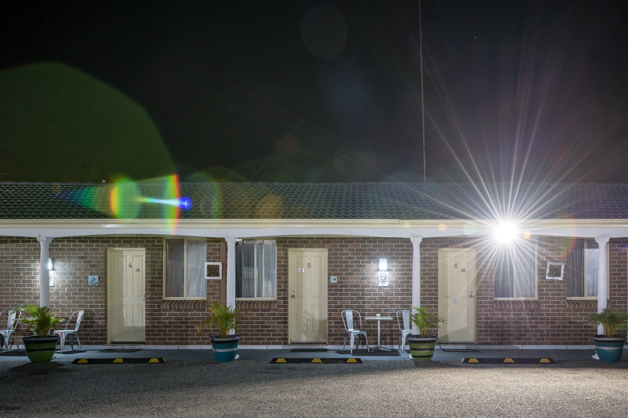 Bucaneer Motel at Hotel Motel 101, brown brick facade, single storey, three rooms numbered 4, 5 and 6.