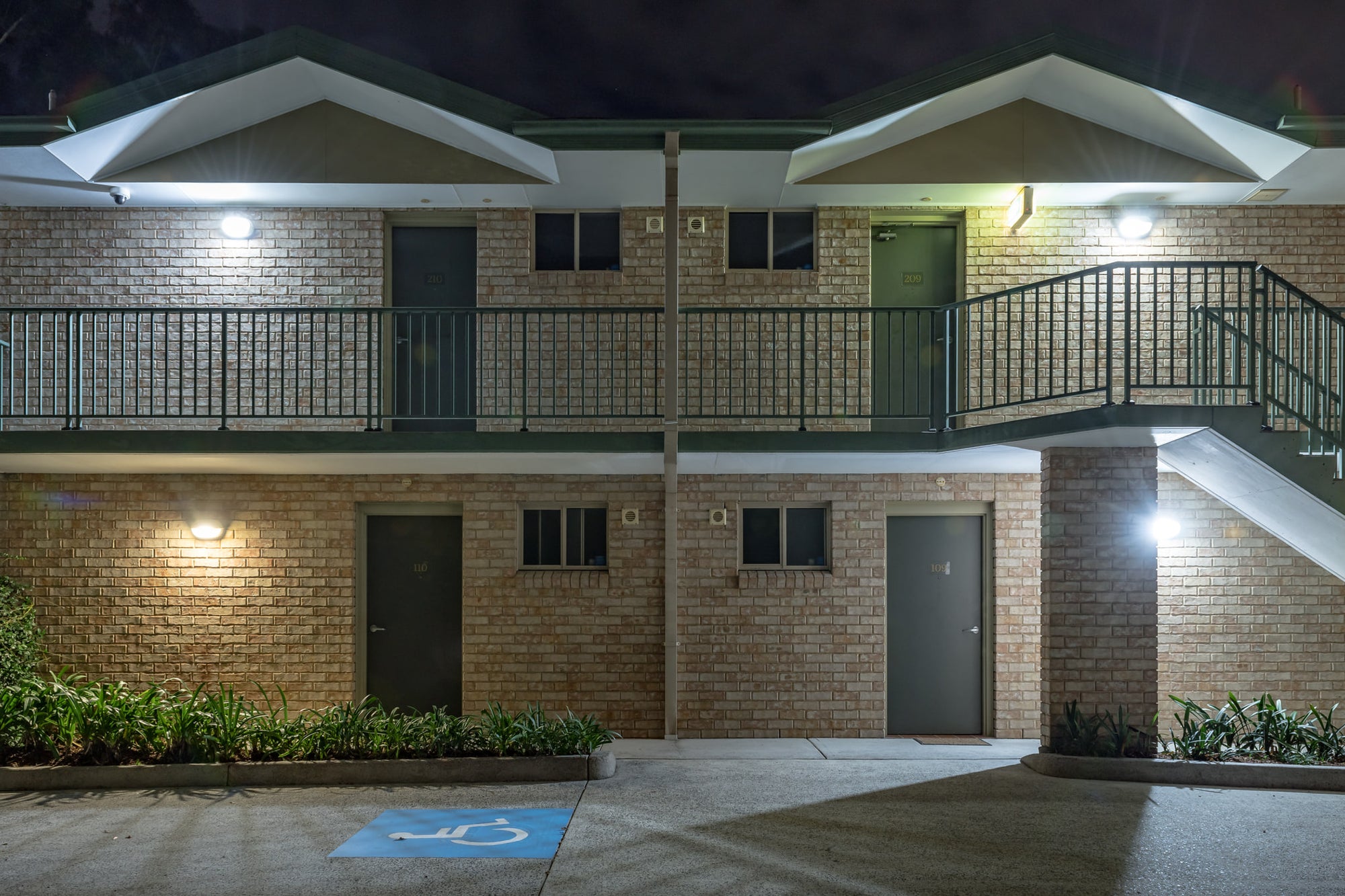 Chittaway Motel at Hotel Motel 101, two storeys of cream brick face the empty car park.