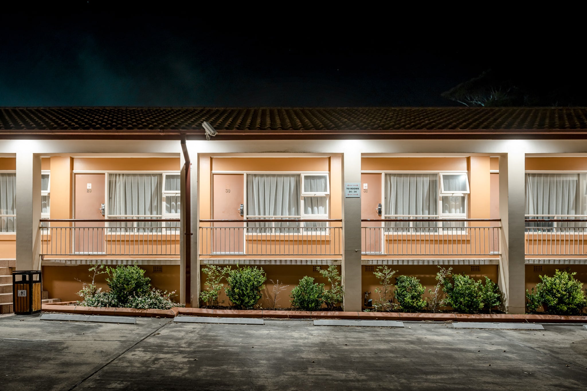 Engadine Motor Inn at Hotel Motel 101, peach-coloured render and concrete pillars divide the facade into identical bays.