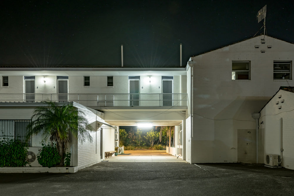 Ettalong Beach Motel at Hotel Motel 101, a two-storey motel block sits under a dark sky, its white-painted brick washed.