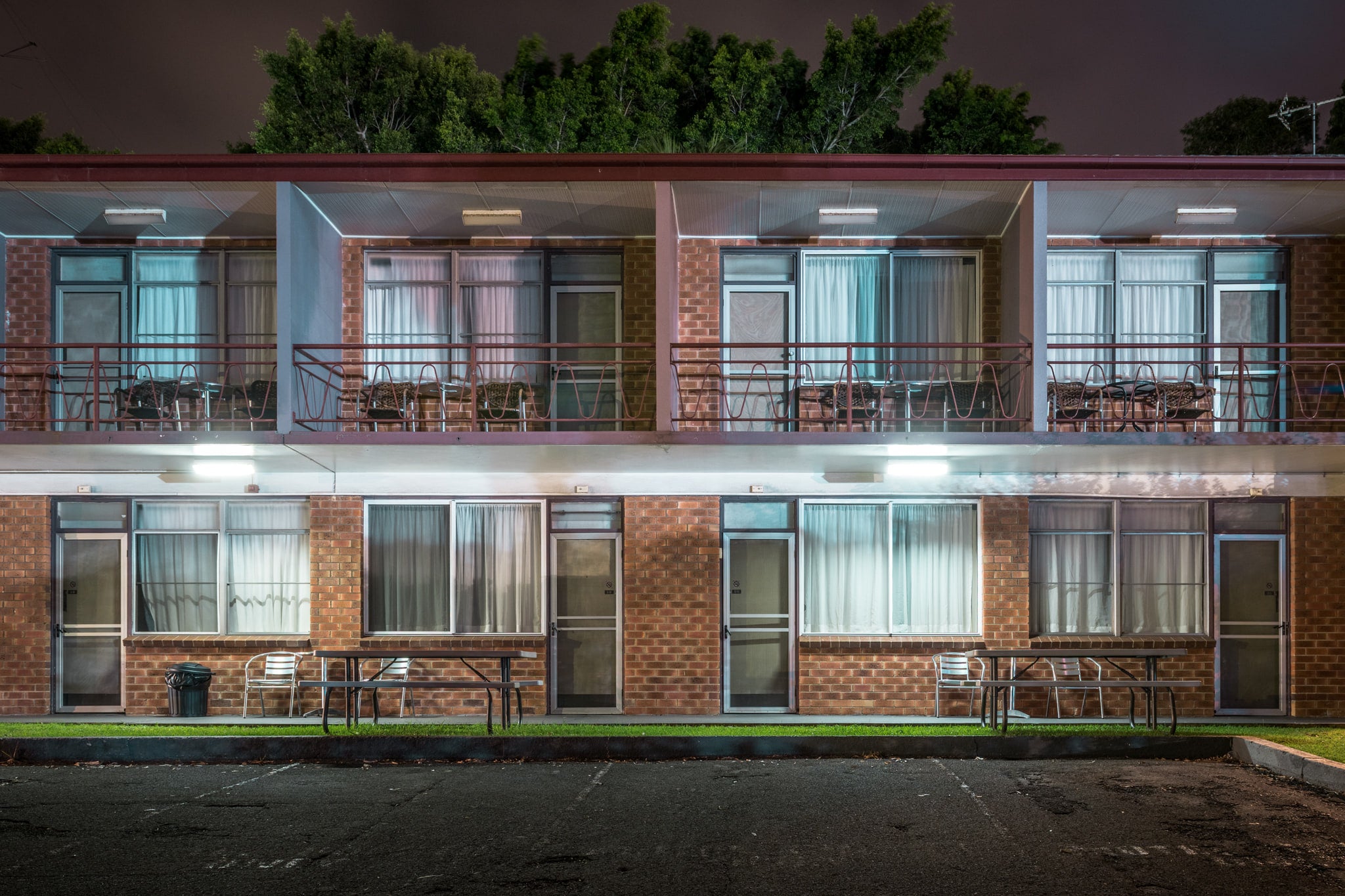 Flinders Motel, Wollongong at Hotel Motel 101, two levels of a low rise motel with car parking spaces in front and trees.