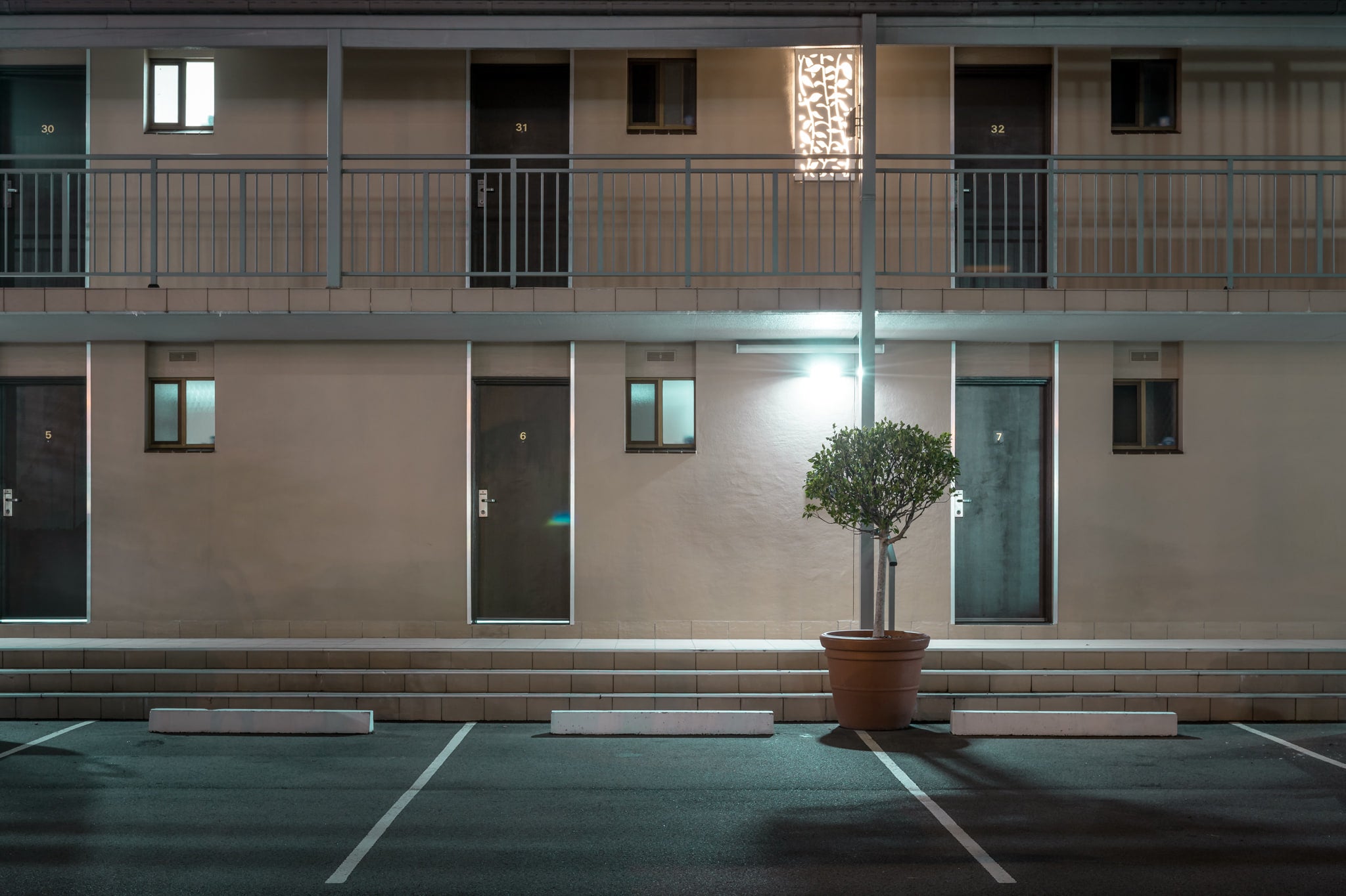 Galaxy Motel at Hotel Motel 101, two storeys of rendered masonry and blockwork face an empty car park.