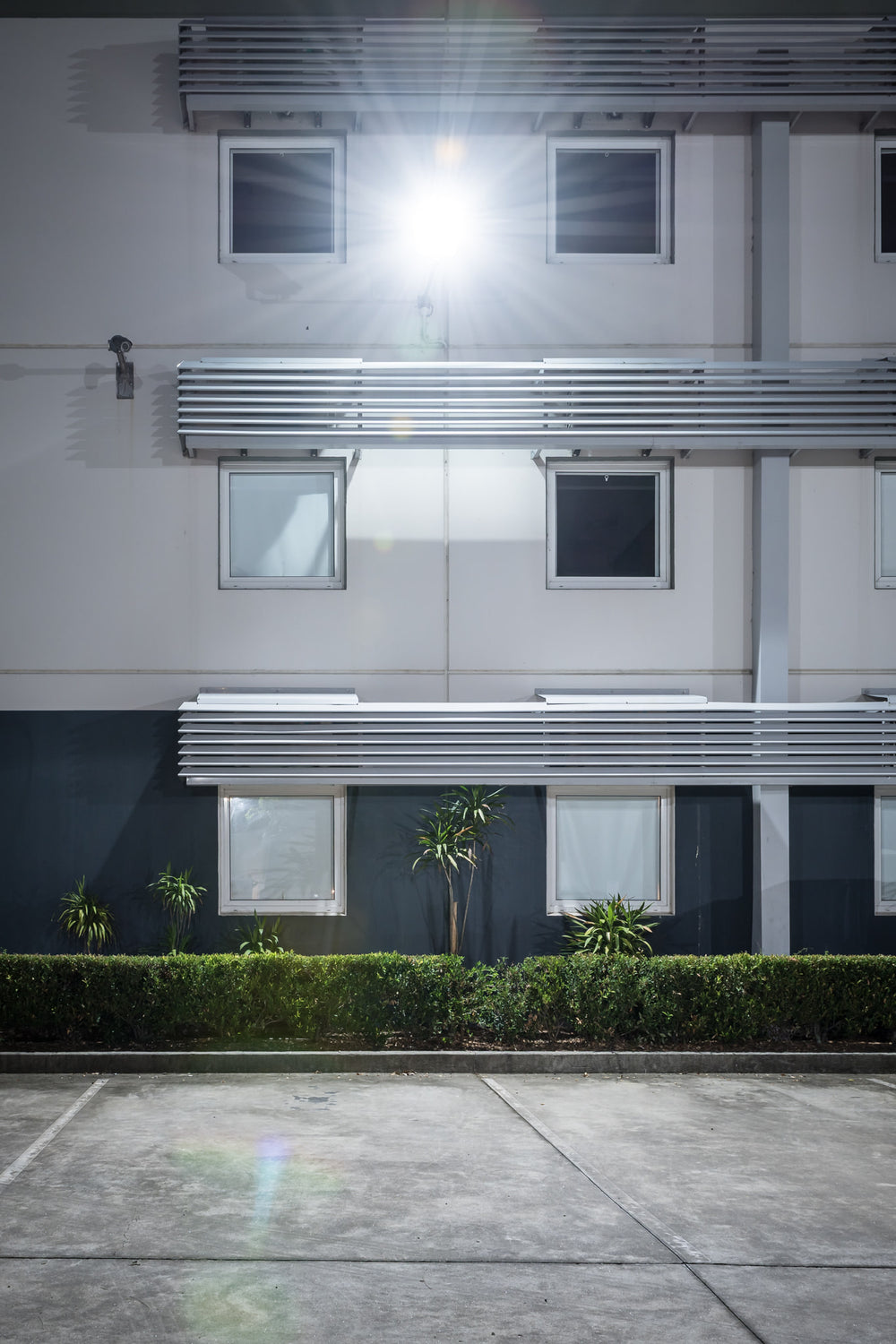 Ibis Budget Gosford at Hotel Motel 101, a two-storey motel facade, shot straight on at night.