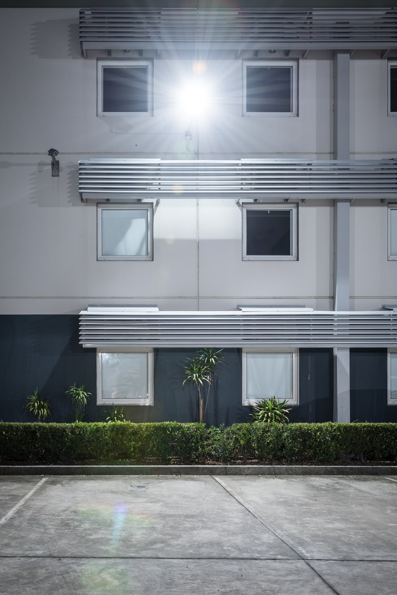 Ibis Budget Gosford at Hotel Motel 101, a two-storey motel facade, shot straight on at night.