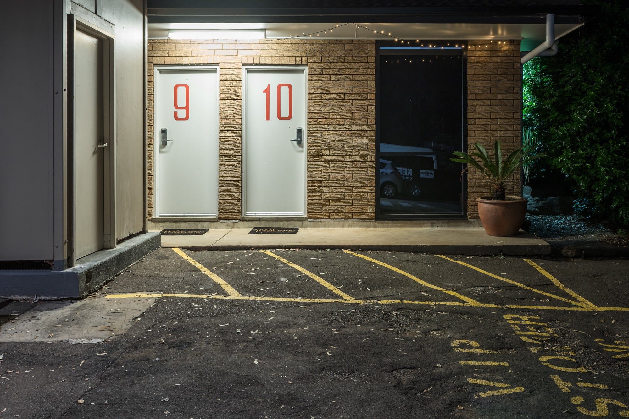 Jamison Hotel at Hotel Motel 101, rooms 9 and 10 sit side by side behind white doors marked with large red numerals.