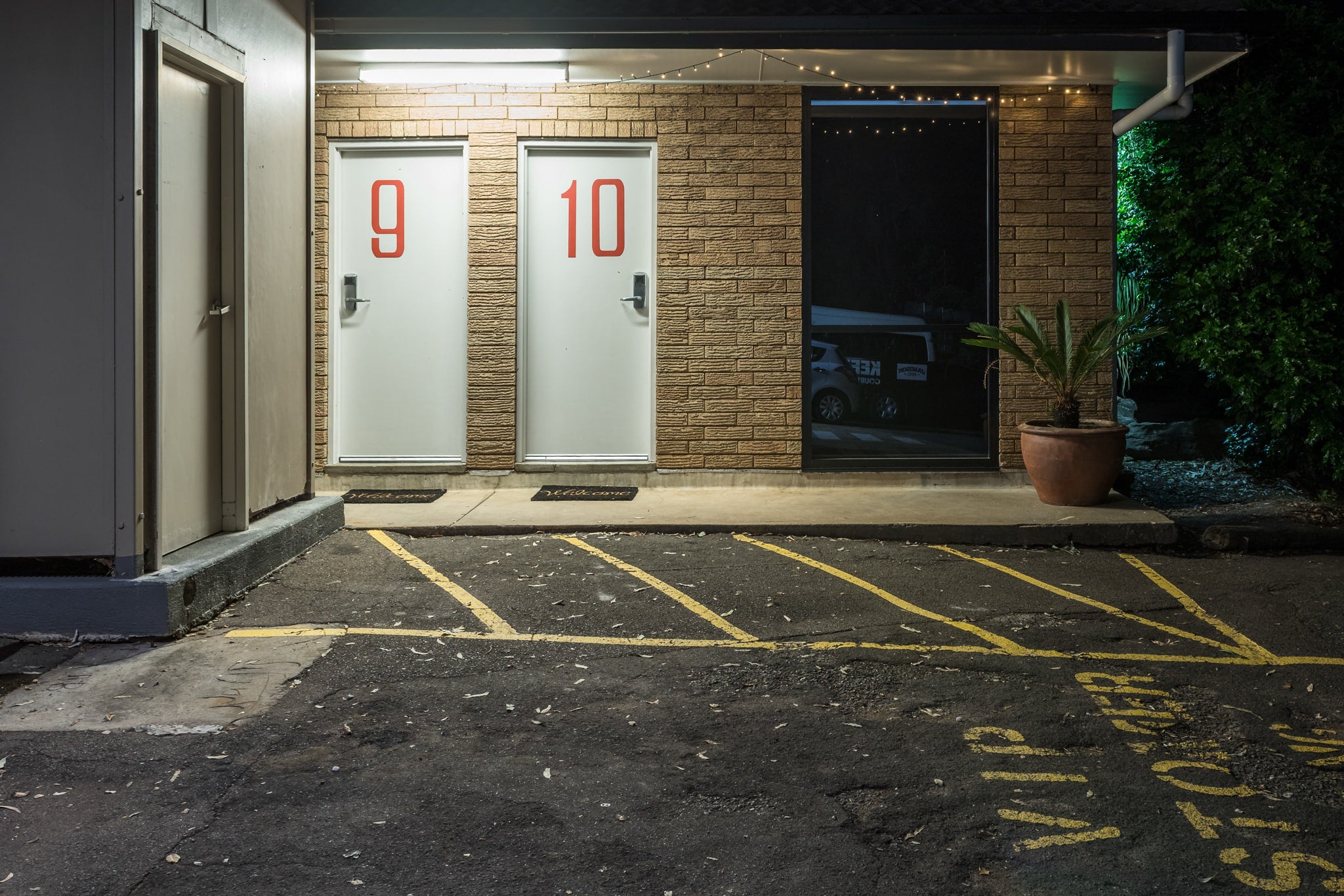 Jamison Hotel at Hotel Motel 101, rooms 9 and 10 sit side by side behind white doors marked with large red numerals.